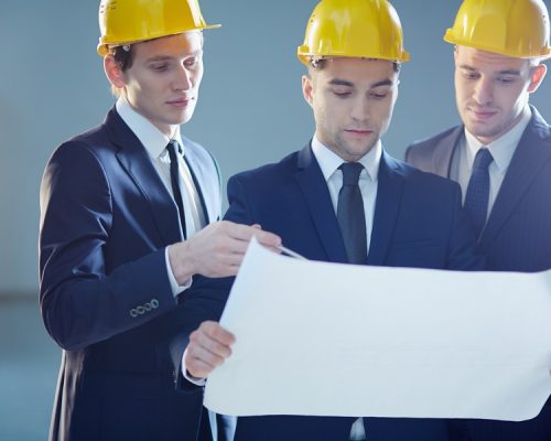 Closeup image of three constructors developing the business project